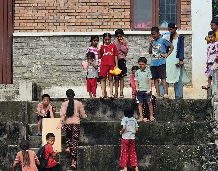Flomrammede barn fra Nepal leker i en trapp på nødmottaket.